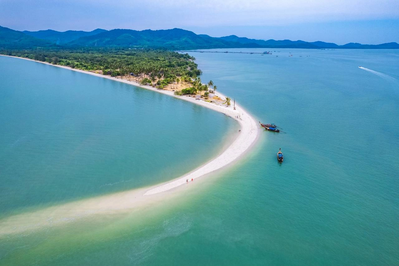 Empty white sand beach on Koh Yao Yai with limestone karsts in distance